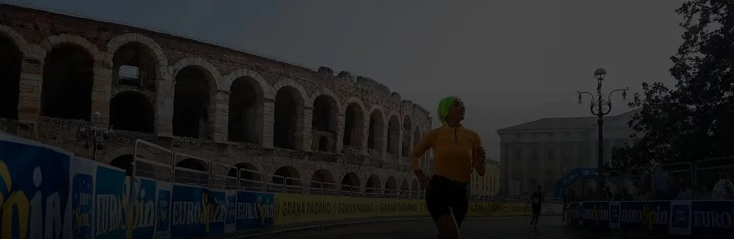Una runner davanti all'Arena di Verona durante la maratona